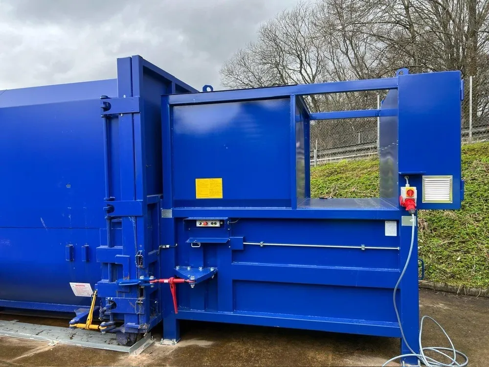 Blue static waste compactor serviced by MJC